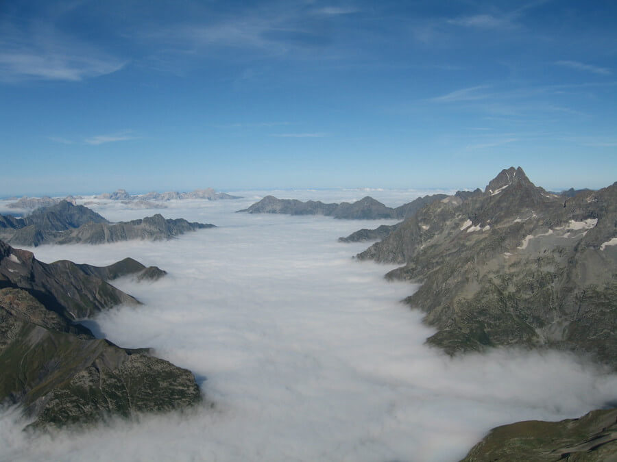 Mer de nuages recouvrant une vallée alpine provoquée par une inversion thermique